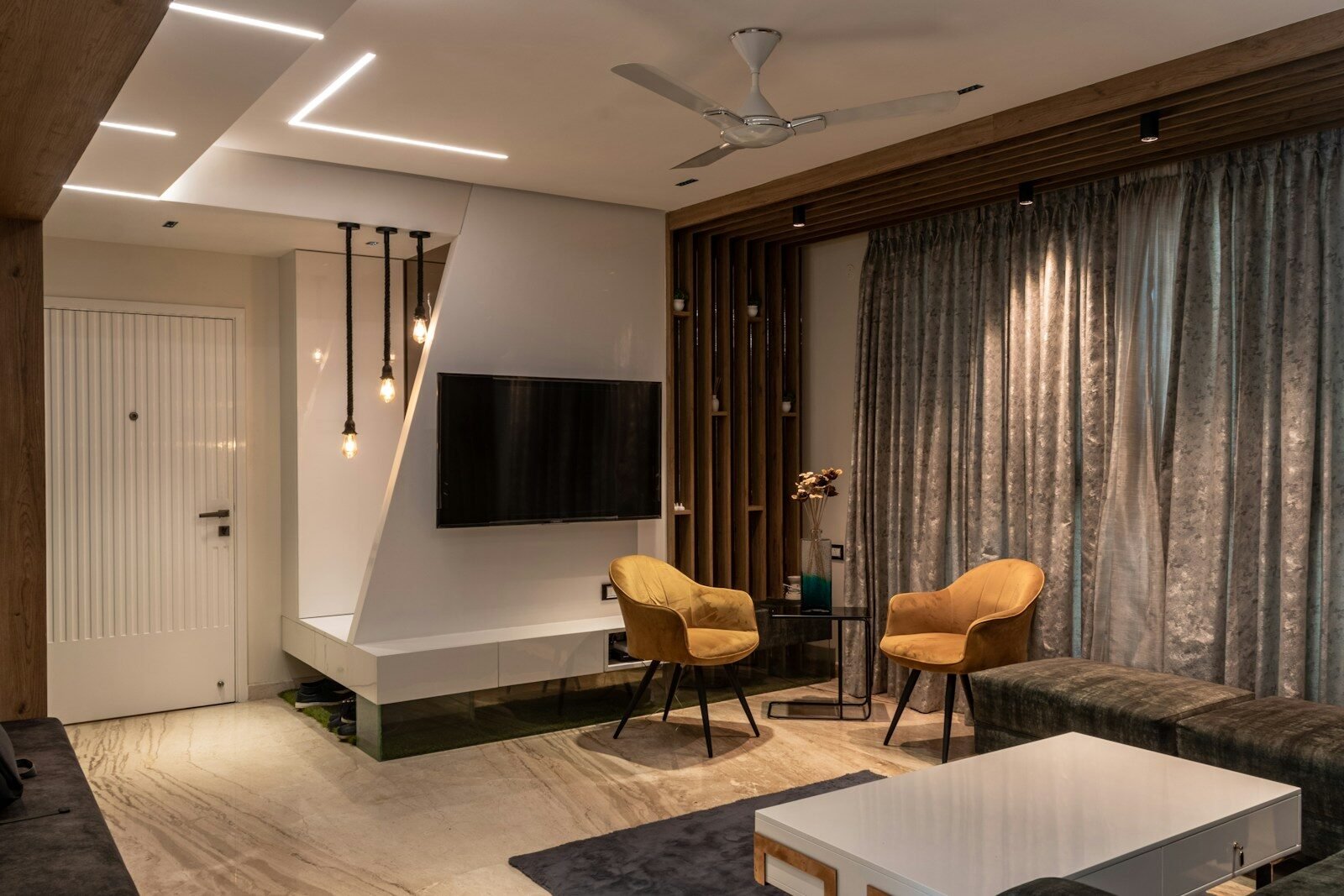 a living room with a tv and chairs
